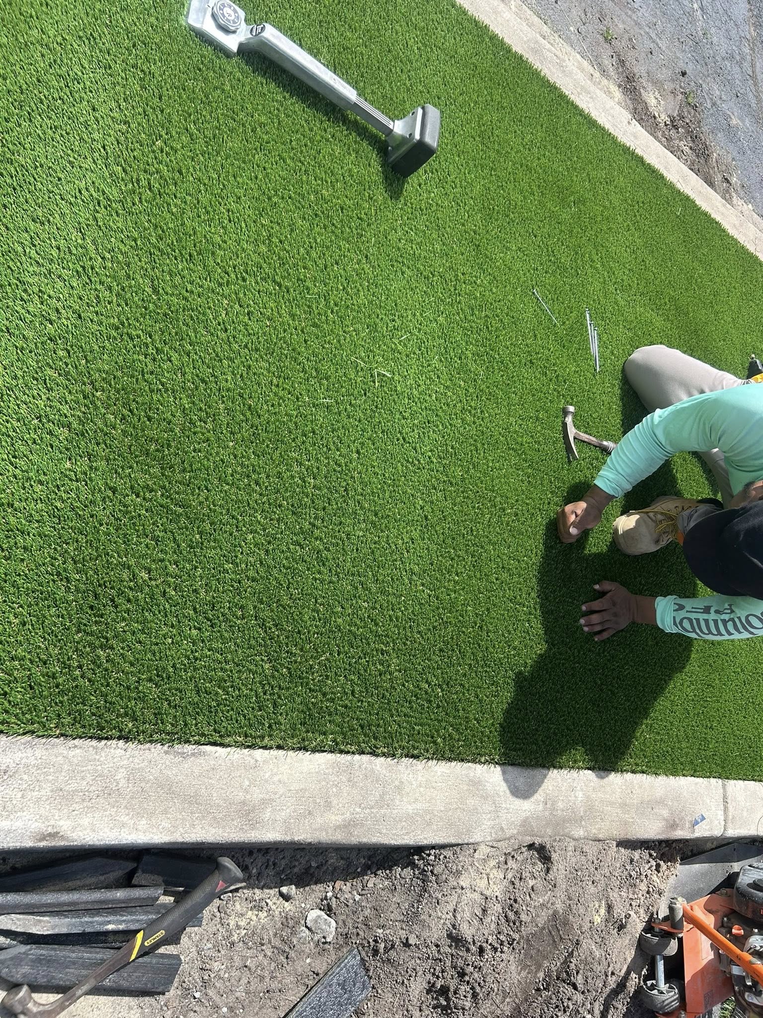 Removed shrubs, and installed artificial turf for dealership